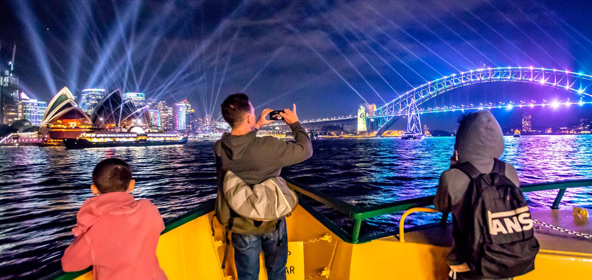 Visitors taking photos from Sydney Ferry of the Sydney Harbour Bridge